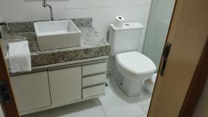 Un baño con un inodoro blanco y un lavabo. en Apartamento centro, en Ubá