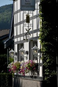 a white building with flowers in a window at Landidyll Hotel Haus Hochstein in Wenholthausen