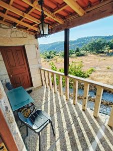 eine Terrasse mit einem Tisch und einem Stuhl auf einer Veranda in der Unterkunft Quinta das Amendoeiras in Mêda