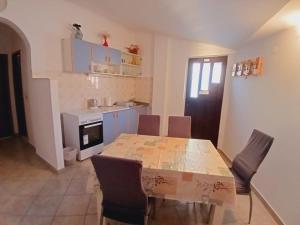a dining room with a table and chairs and a kitchen at Apartment Vlatka in Rogoznica
