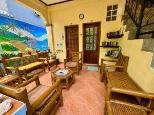 a living room with wooden benches and tables at Ocean Breeze Inn in Boracay