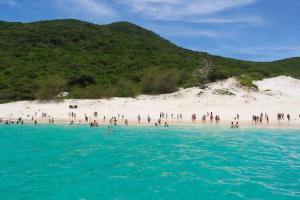 a group of people standing on a beach at Casa - Praia dos Anjos - Arraial do Cabo - Aluguel Econômico in Arraial do Cabo