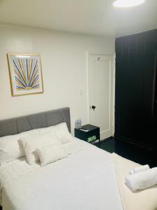 a bedroom with a large bed with white sheets at 1940s Urban charmer modern upgrades in Auburn +1 photo