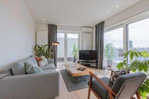 a living room with a couch and a tv at Huswell - Spacious apartment in Ghent with big terrace in Ghent