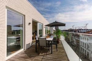 a balcony with a table and an umbrella at Huswell - Spacious apartment in Ghent with big terrace in Ghent
