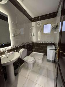 un baño con inodoro y lavabo en شقق عمر الفندقية, en Medina