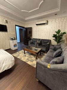 Una sala de estar con un sofá y una mesa de café. en شقق عمر الفندقية, en Medina