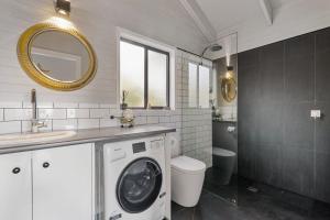 a bathroom with a washing machine and a sink at Martha's Villa - Panoramic, Peaceful Location in Kangaroo Valley +9 photos