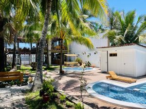 a resort with a swimming pool and palm trees at The Beach Break Hotel El Cocal in Playa San Blas