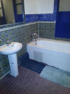 a bathroom with a sink and a bath tub and a sink at Riad Dar Kader chambre bleue in Marrakesh