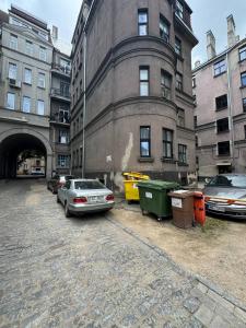 Un estacionamiento con autos estacionados frente a un edificio. en Eksporta Appartaments, en Riga