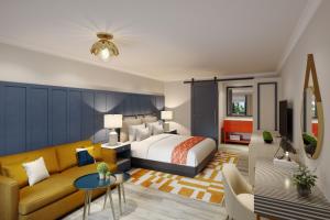 a bedroom with a bed and a couch at Tiller House, Laguna Hills, a Tribute Portfolio Hotel in Laguna Hills