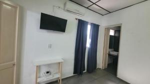 a room with a television on a white wall at Departamento Mis Nonos 4 in Mendoza