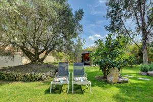 Dos sillas sentadas en el césped de un patio. en Best Western Sévan Parc Hôtel, en Pertuis