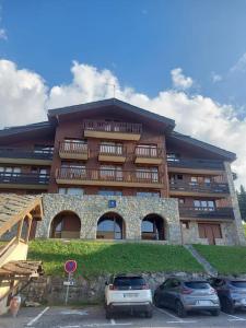 レ・コシュにあるappartement aux coches 23m2 6 personnes 1 chambreの前に車が駐車されている大きな建物