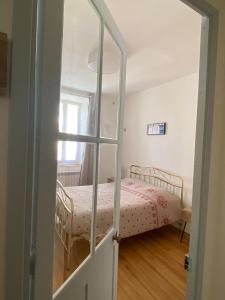 ein Schlafzimmer mit einem Bett und einer Glastür in der Unterkunft Appartements centre-ville in Bagnères-de-Bigorre