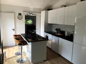a kitchen with white cabinets and black counter tops at Home Sweet Home in Loos
