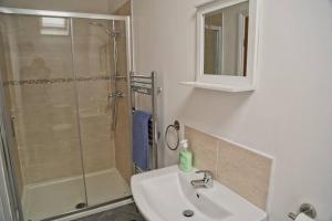a bathroom with a shower and a sink and a mirror at White Swan Cottage in Hunmanby +4 photos