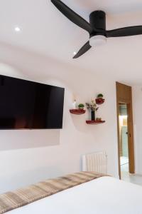 une chambre avec un ventilateur de plafond et une télévision au mur dans l'établissement Luxury apartment at Torrevieja Beach, à Torrevieja