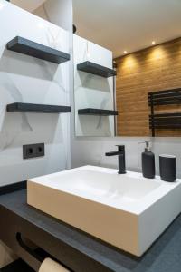 une salle de bains avec un lavabo blanc et un miroir dans l'établissement Luxury apartment at Torrevieja Beach, à Torrevieja