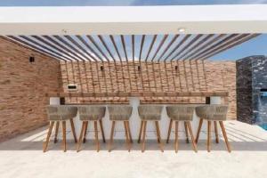 a bar with six chairs in front of a brick wall at Depto ideal para tu viaje in Playa del Carmen