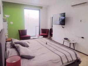 a large bed in a room with two chairs at Depto ideal para tu viaje in Playa del Carmen