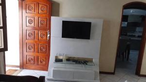 a living room with a tv on a wall at Casa - Praia dos Anjos - Arraial do Cabo - Aluguel Econômico in Arraial do Cabo