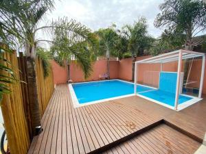 a swimming pool with a gazebo on a wooden deck at Casa charmosa condomínio piscina Praia de Juquehy, São Sebastião in Juquei