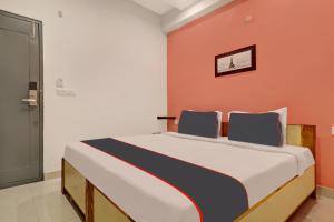 een slaapkamer met een groot bed met een oranje muur bij Super Capital O Qualia Gachibowli in Hyderabad