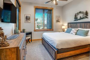 ein Schlafzimmer mit Bett, Schreibtisch und Fenster in der Unterkunft Modern Elk Creek Condo with Hot Tub and Heated Floors in Fraser