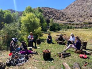 a group of people sitting around a camp fire at Glamping Catarata Capua in Yura