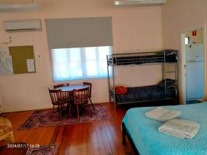 a bedroom with a bunk bed and a table and chairs at Tamarind Gardens Camping, Caravans, Accommodation in Almaden