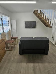 a bedroom with a bed in a room with a staircase at Cottage in Puhoi