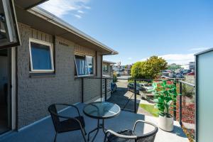 a patio with a table and chairs on a balcony at Stay in Town in Taupo