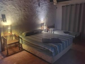 a bedroom with two beds in a stone wall at Hostel Ysapy en Piribebuy - Paraguay in Piribebuy