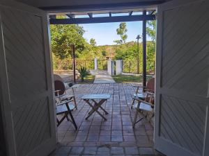 an open door to a patio with chairs and a table at Hostel Ysapy en Piribebuy - Paraguay in Piribebuy