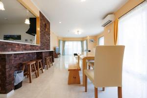 a dining room with a table and some chairs at オーシャンビューテラス伊豆 in Futo