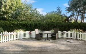 two chairs sitting in front of a white fence at 3 Bedroom Cozy Home In Nykøbing Sj in Lumsås