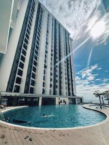a large building with a swimming pool in front of it at The Shore Cozy Suite in CBD in Kota Kinabalu