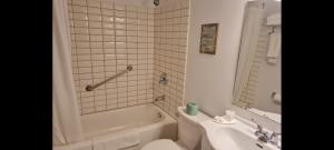 a bathroom with a tub and a toilet and a sink at The Inn At Lock Seven in Thorold