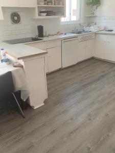 a kitchen with white cabinets and a wooden floor at Montréal Steps Downtown Private Rooms in Montreal