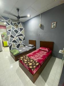 a bedroom with two beds and a ceiling at D'Murni Beach Homestay in Yan