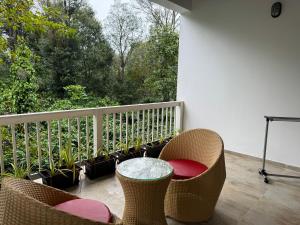 balcone con sedie, tavolo e alcune piante di The Caligo resort coorg a Madikeri