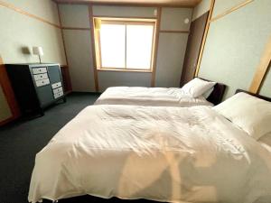 Postel nebo postele na pokoji v ubytování Ember Lodge - Hakuba