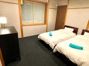 Postel nebo postele na pokoji v ubytování Ember Lodge - Hakuba