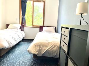 Postel nebo postele na pokoji v ubytování Ember Lodge - Hakuba