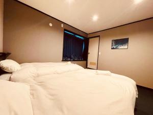 Postel nebo postele na pokoji v ubytování Ember Lodge - Hakuba