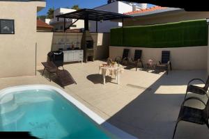 een achtertuin met een zwembad en een tafel en stoelen bij El Badan Hospedagem - Casa 3 in Olímpia