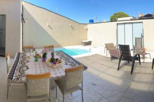 een tafel en stoelen op een patio naast een zwembad bij El Badan Hospedagem - Casa 3 in Olímpia