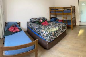 een slaapkamer met 2 bedden en een stapelbed bij El Badan Hospedagem - Casa 3 in Olímpia